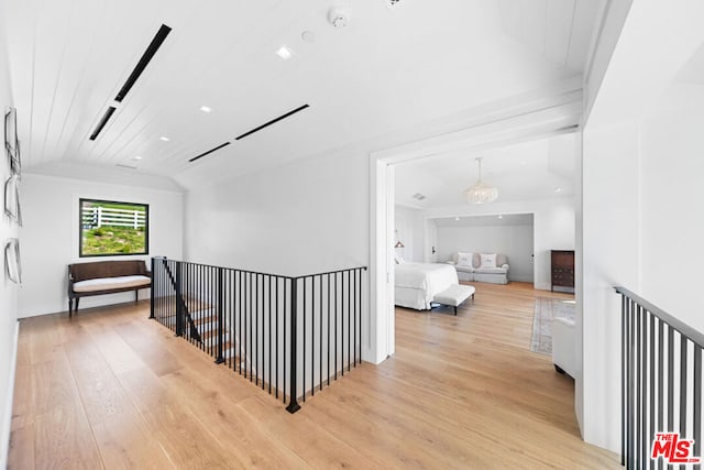 hall with an inviting chandelier, lofted ceiling, wood ceiling, and light hardwood / wood-style flooring