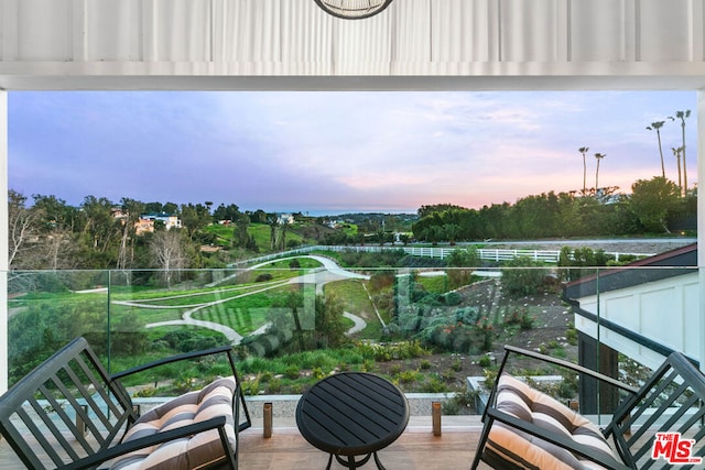 balcony at dusk featuring an outdoor hangout area