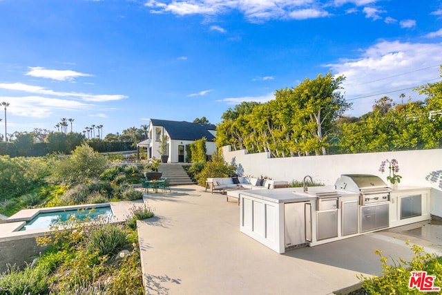 view of patio featuring exterior kitchen, an outdoor hangout area, area for grilling, and a fenced in pool