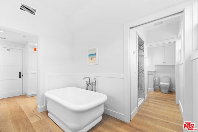 bathroom with independent shower and bath, hardwood / wood-style flooring, and toilet