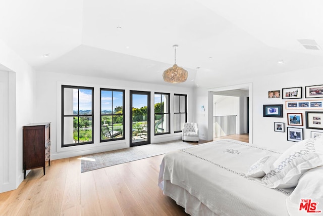 bedroom with lofted ceiling, light hardwood / wood-style floors, and access to outside