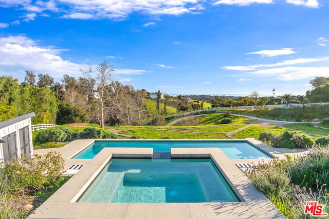 view of swimming pool with an in ground hot tub