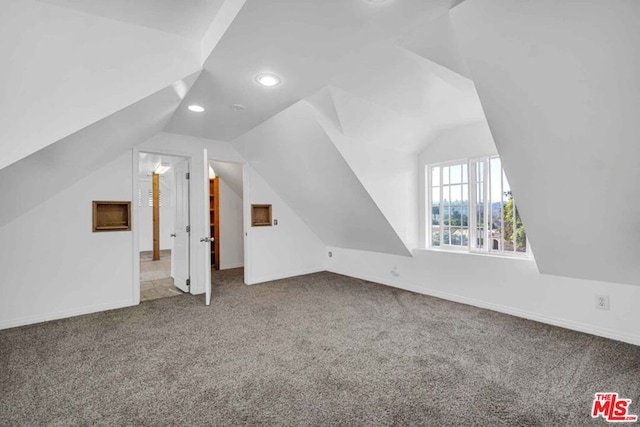 bonus room with carpet and vaulted ceiling