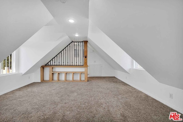 bonus room featuring lofted ceiling and carpet