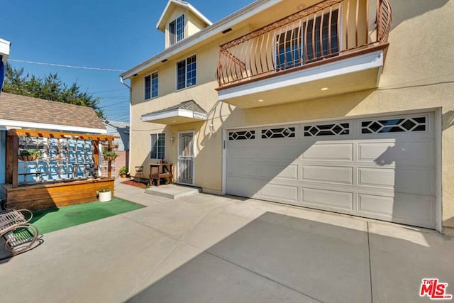 view of front of property featuring a garage and a balcony