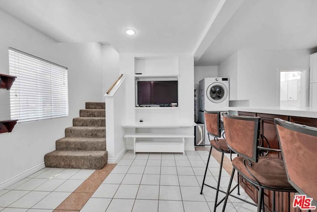 interior space with stacked washing maching and dryer and light tile patterned flooring