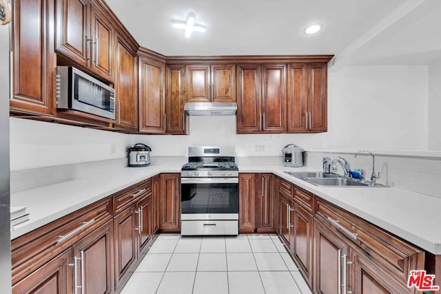 kitchen with sink, appliances with stainless steel finishes, and light tile patterned floors