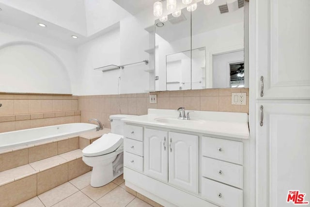 bathroom featuring vanity, toilet, tile patterned flooring, and tiled tub