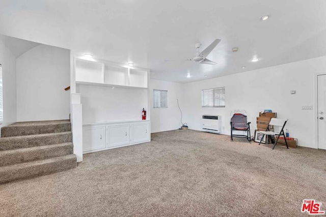 living area with heating unit, carpet, and ceiling fan