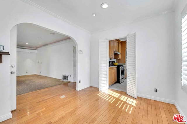 interior space with ornamental molding and light hardwood / wood-style flooring