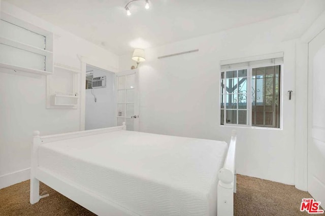 bedroom featuring a wall mounted air conditioner and carpet