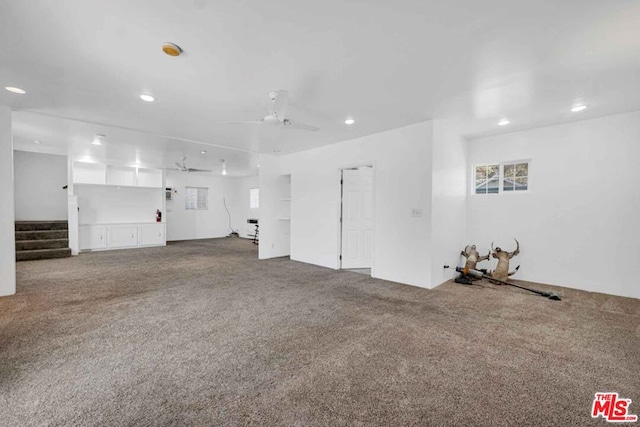 unfurnished living room featuring carpet flooring and ceiling fan