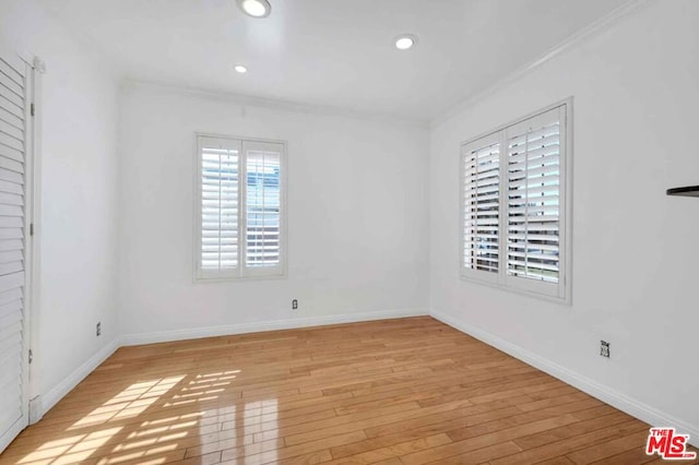 empty room featuring light hardwood / wood-style floors and crown molding