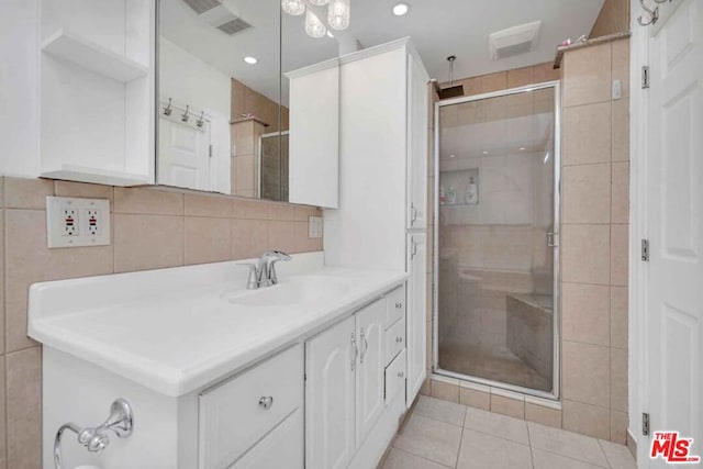 bathroom featuring vanity, a shower with shower door, tile patterned floors, and tile walls