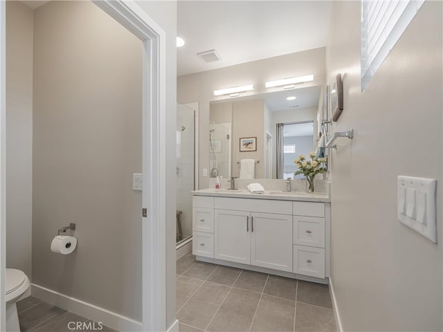 bathroom featuring tile patterned floors, vanity, a shower with door, and toilet