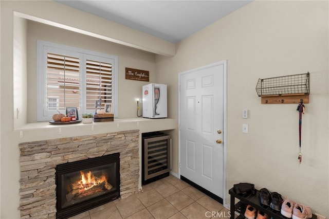 bar with wine cooler, a fireplace, and light tile patterned floors