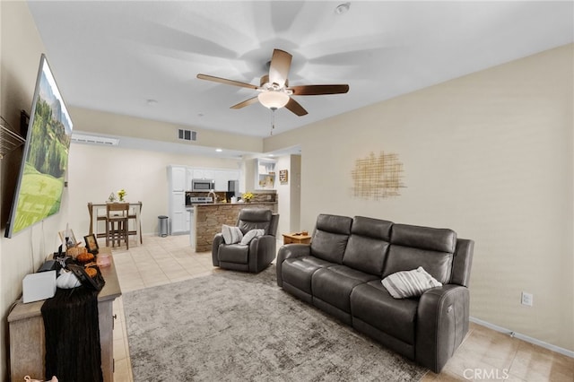 tiled living room featuring ceiling fan