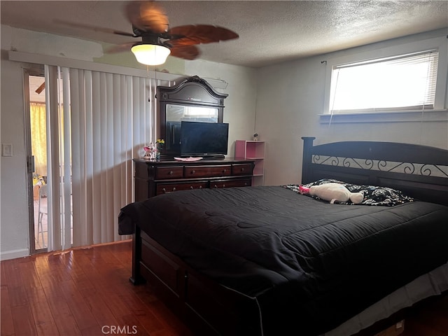 bedroom with a textured ceiling, ceiling fan, and dark hardwood / wood-style flooring