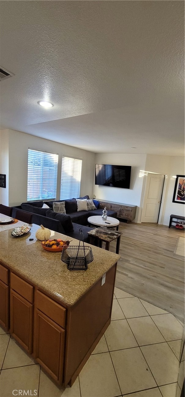 living room featuring a textured ceiling and light wood-type flooring