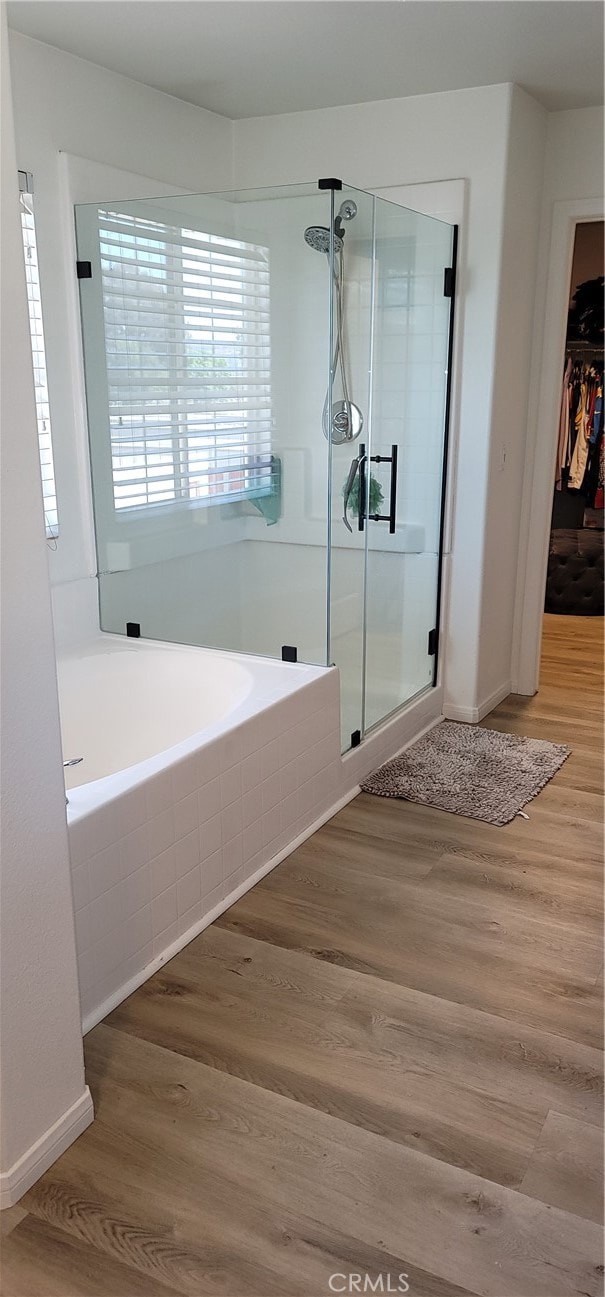 bathroom with wood-type flooring and plus walk in shower