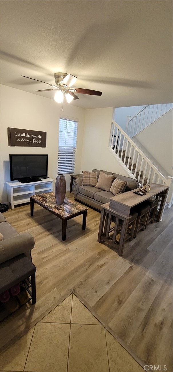 living room featuring a textured ceiling, hardwood / wood-style flooring, and ceiling fan