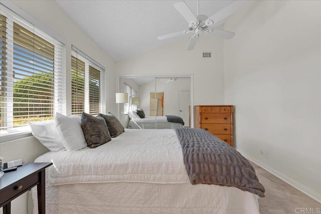 bedroom featuring multiple windows, ceiling fan, a closet, and lofted ceiling