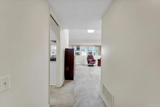 hall with a textured ceiling