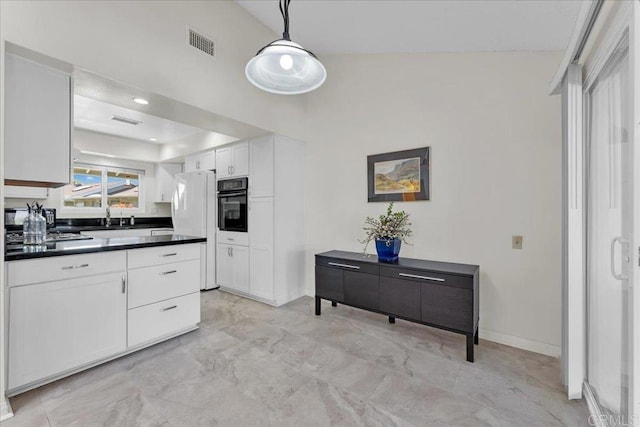 kitchen with white refrigerator, oven, decorative light fixtures, vaulted ceiling, and white cabinets