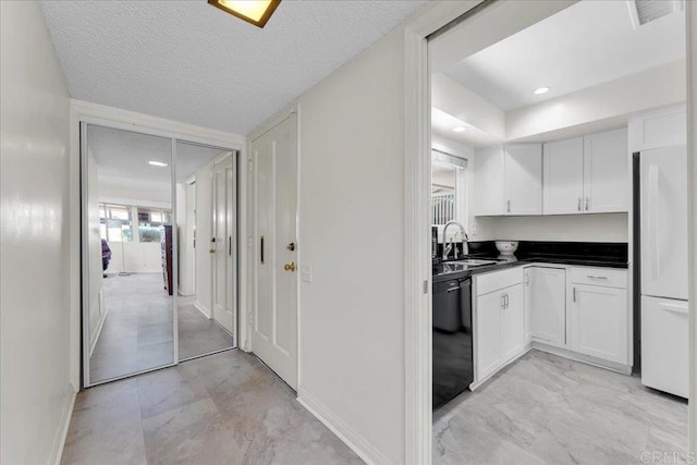 3685 Vista Campana N Unit 56, Oceanside, CA 92057 - kitchen with dishwasher, white refrigerator, white cabinetry, dark countertops, and a textured ceiling