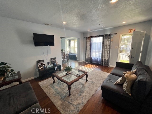 living room with dark wood-type flooring and a textured ceiling