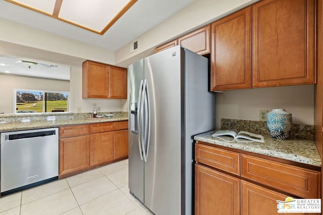 kitchen featuring light stone counters, light tile patterned floors, and appliances with stainless steel finishes