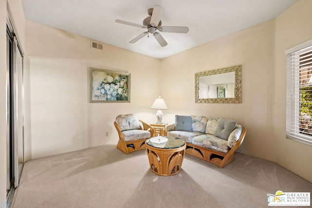 carpeted living room with ceiling fan