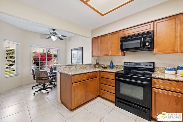 kitchen with black appliances, ceiling fan, light tile patterned floors, light stone counters, and kitchen peninsula