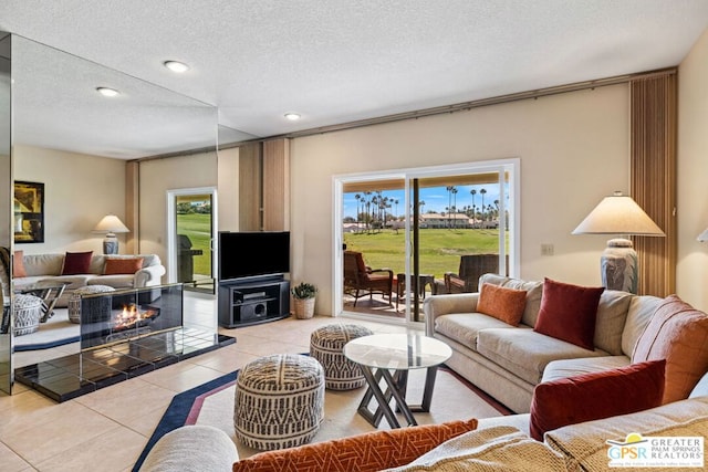 living room featuring a fireplace, light tile patterned floors, and a textured ceiling