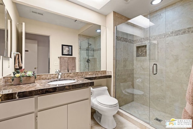 bathroom with tile patterned flooring, vanity, toilet, and a shower with door