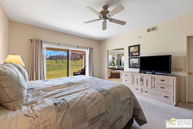 bedroom featuring ceiling fan, access to exterior, a textured ceiling, connected bathroom, and light colored carpet