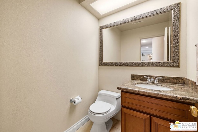 bathroom with tile patterned flooring, vanity, and toilet