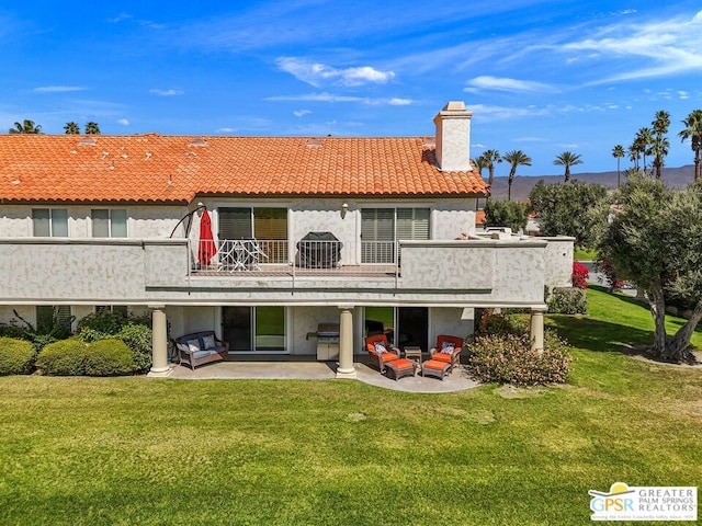 rear view of property with a lawn, a balcony, a patio, and an outdoor hangout area