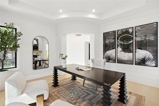 living room with hardwood / wood-style floors and a raised ceiling