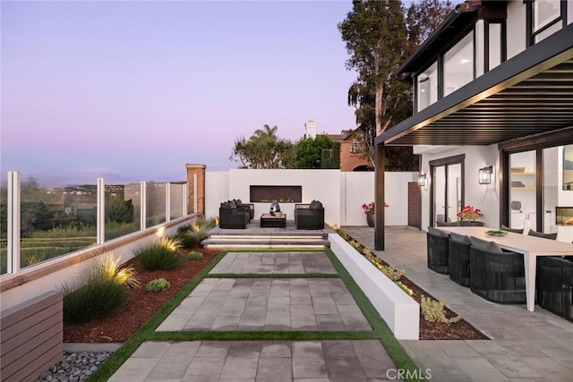 patio terrace at dusk featuring outdoor lounge area