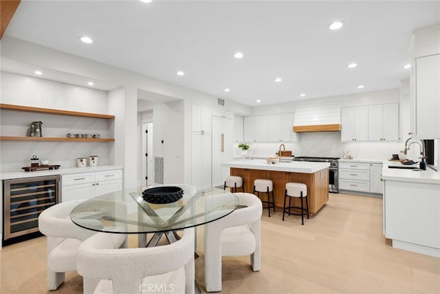 dining room featuring sink, beverage cooler, and light wood-type flooring