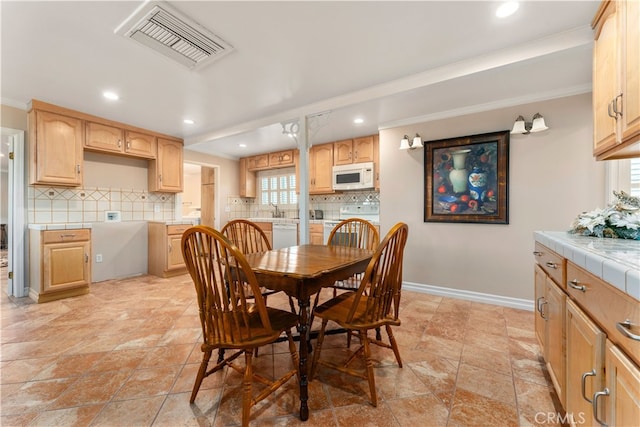 dining room with crown molding and sink