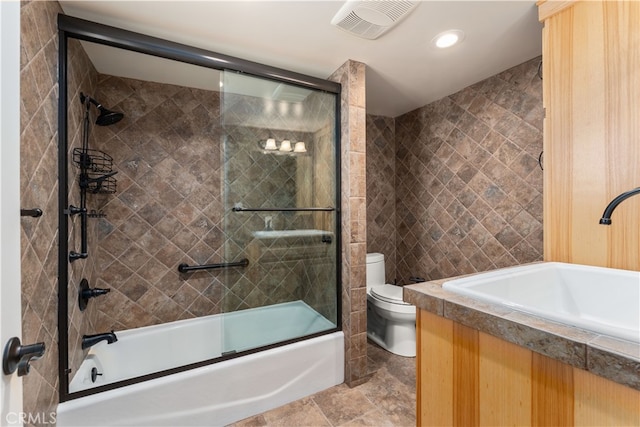 full bathroom with combined bath / shower with glass door, vanity, and toilet