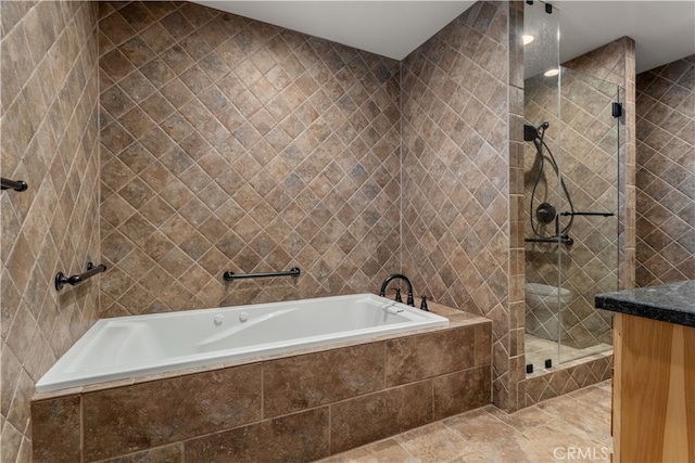 bathroom with tile patterned flooring, separate shower and tub, vanity, and tile walls