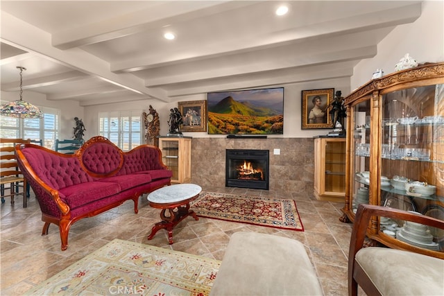 living room featuring tile walls, beam ceiling, and a tile fireplace