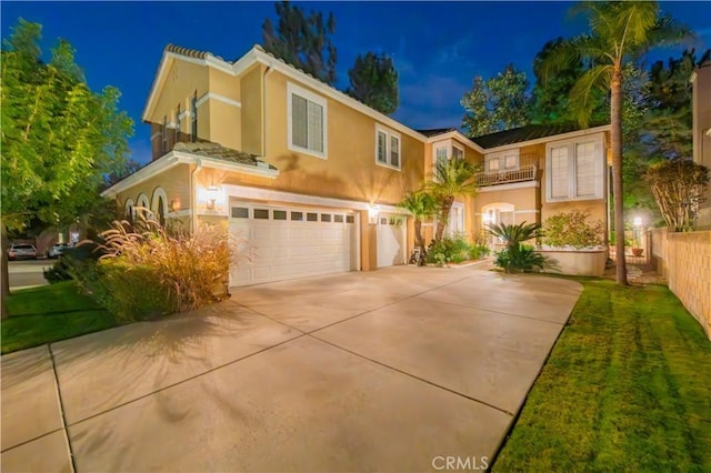 view of front of home featuring a front lawn, a garage, and a balcony