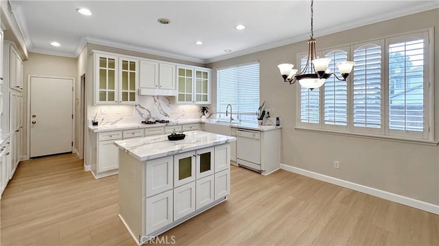 kitchen featuring a sink, light wood-type flooring, dishwasher, and an inviting chandelier