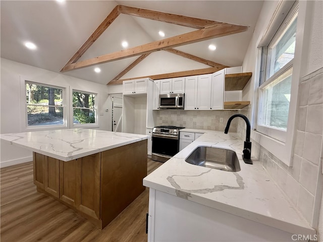 kitchen featuring light stone countertops, appliances with stainless steel finishes, sink, white cabinetry, and hardwood / wood-style flooring