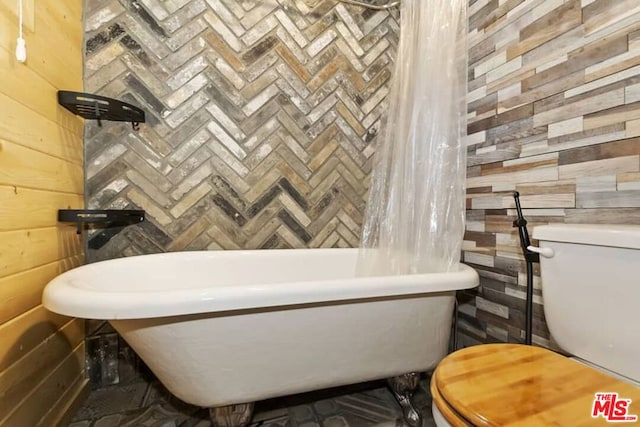 bathroom with toilet and wooden walls