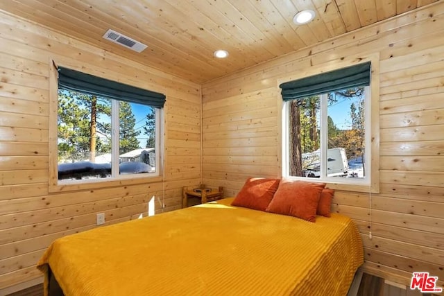 bedroom featuring wooden walls and wood ceiling